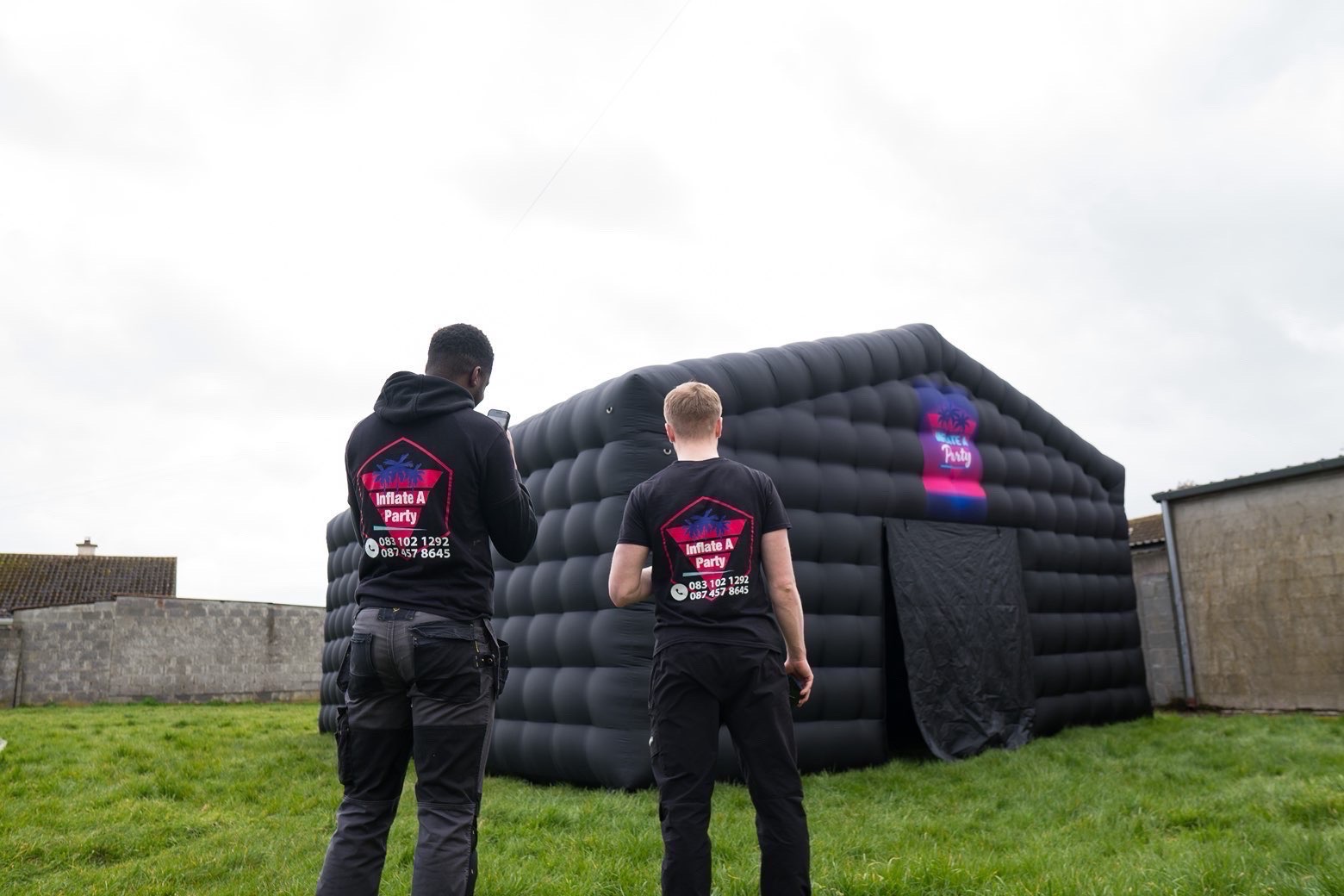Inflate A Party team with branded merch in front of the tent